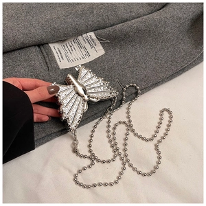 Macro shot of silver butterfly clutch bag with white rhinestones and ball chain
