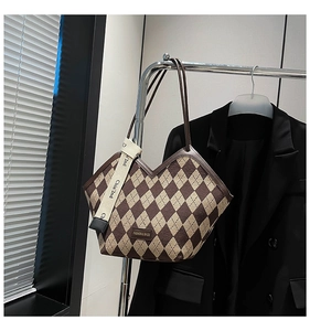 Detail of rhombic lattice tote bag with V-shaped opening and stylish ribbon straps