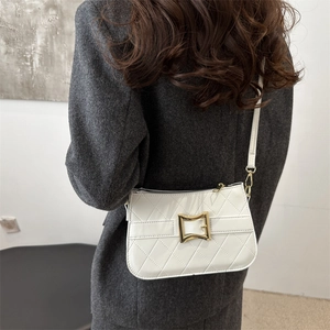 White quilted crossbody bag with gold metal buckle and slender shoulder strap for women