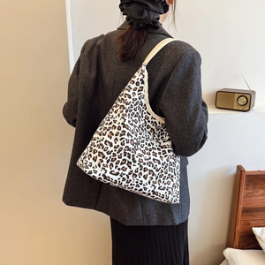 Minimalist leopard print canvas tote bag shown as a spacious shoulder bag on a model