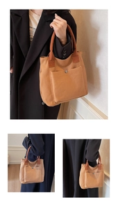 Détail du sac fourre-tout en toile marron avec poche avant et bouton-pression en métal