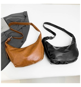 Detail of vintage faux leather crescent bag showing adjustable buckle and texture