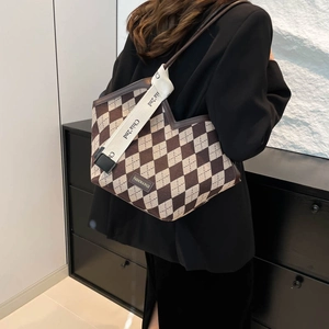 Fashionable argyle patterned tote bag with beige canvas strap shown on a model