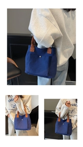 Détail du sac en toile bleu marine avec anses brunes et poche avant à fermoir magnétique