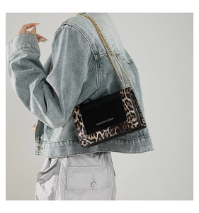 Detail of leopard print patchwork crossbody bag with gold chain strap on model