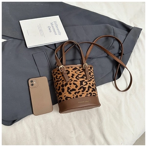 Detailed top view of leopard print bucket bag with leather handles and fashion lettering