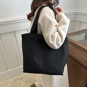 Minimalist black canvas tote bag with large capacity shoulder strap for daily commuting