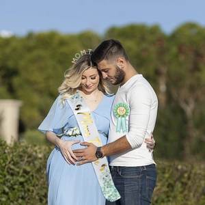 Baby shower party set with Mom To Be sash and Dad To Be badge shown in a park setting