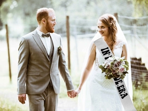 Close-up of glittery silver bridal sash with In My Bride Era text at outdoor wedding
