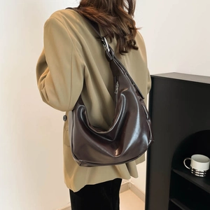 Deep brown half-moon shoulder bag with glossy oil leather texture and wide strap
