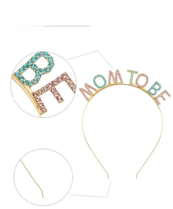 Detail of MOM TO BE gold metal headband with colorful rhinestones and protective tips