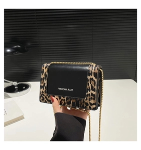 Detail of leopard print patchwork crossbody bag with gold chain and metal lettering