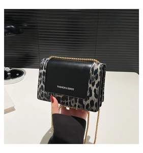 Close-up of leopard print stitching and gold chain strap on the small square bag