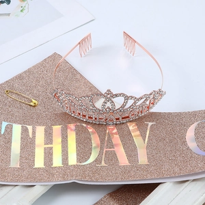 Close-up of rose gold birthday tiara with rhinestones and glittery sash set
