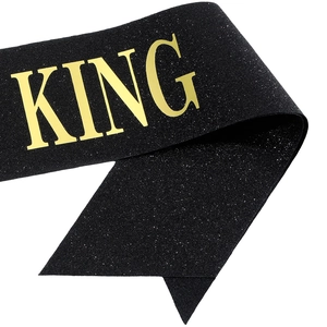 Detail of BIRTHDAY KING sash with gold glitter text on shimmering black fabric