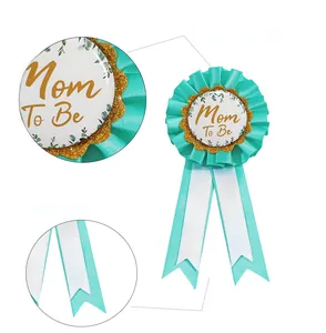 Detailed view of Mom To Be baby shower badge with tiffany blue ribbons and gold glitter