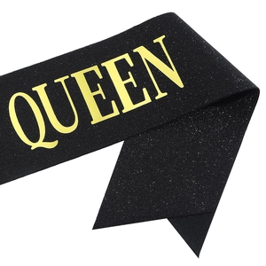 Close-up of black glitter fabric sash with gold QUEEN lettering for birthday party decor