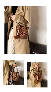 Detail of leopard print bucket bag with brown leather handles and teddy bear charm