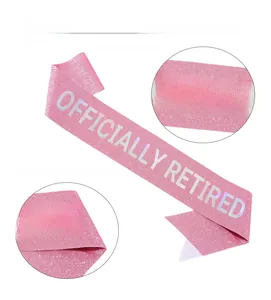 Macro detail of pink glitter fabric sash with metallic OFFICIALLY RETIRED lettering