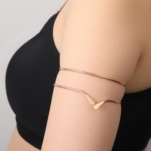 Gros plan d'un bracelet de bras doré double épaisseur au design goutte minimaliste