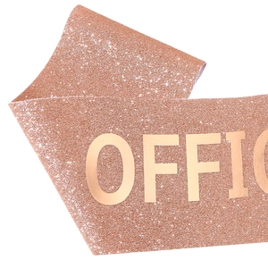 Macro view of rose gold glitter sash with metallic gold Officially Retired text detail