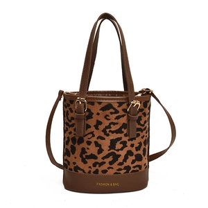 Leopard print bucket bag with brown leather trim and adjustable shoulder strap