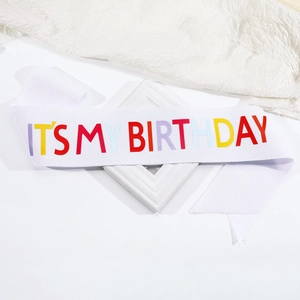 Macro detail of white glitter birthday sash with colorful IT'S MY BIRTHDAY text print