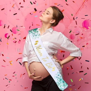 Dettaglio della fascia Mom To Be in raso bianco con scritte dorate per baby shower