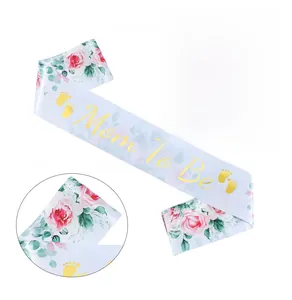Detail of Mom To Be white satin sash with gold foil lettering and pink floral patterns