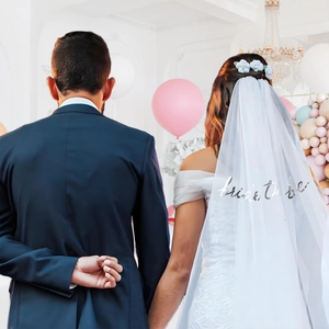 Detail of white double-layer bridal veil with silver bride to be lettering and comb