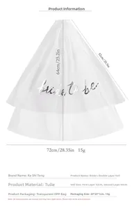 Detailed view of white double-layer bridal veil with silver Bride to be lettering and comb