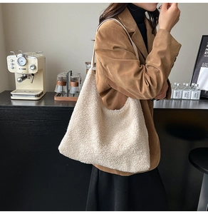 Close-up of cream-white teddy plush tote bag with soft lambskin texture in cozy cafe