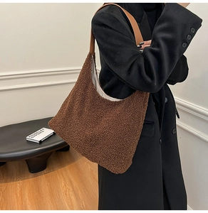 Close-up of brown plush teddy tote bag with premium leather strap for autumn fashion