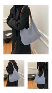 Detail of light blue plush tote bag with brown leather handles and soft fleece texture