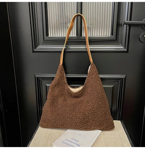 Detail of plush brown tote bag featuring lamb wool texture and faux leather straps