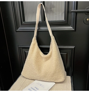 Close-up of beige faux fur tote bag with plush texture and leather shoulder strap