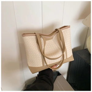 Detail of woven faux leather texture and dual-tone design on a large tote bag