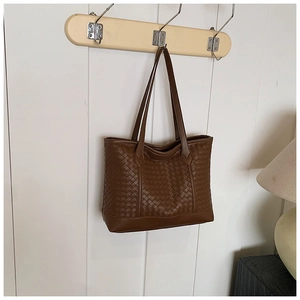 Macro detail showing the intricate dark brown woven leather texture on the large tote bag