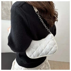 Detail of white quilted nylon underarm bag featuring silver chain strap and zipper closure