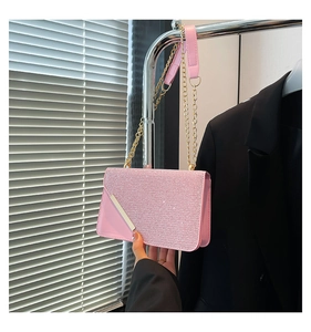 Detail of pink sequin evening bag with gold metal chain and faux leather trim