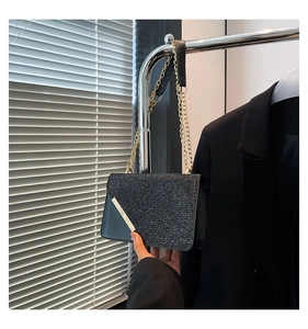 Close-up of black sequin crossbody bag with silver metal detail and gold chain strap