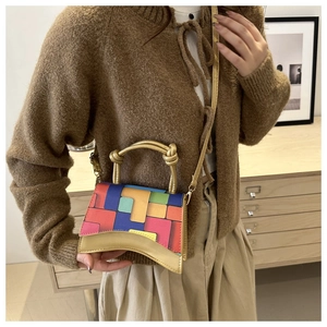 Détail du sac bandoulière avec blocs géométriques colorés et base en croissant unique