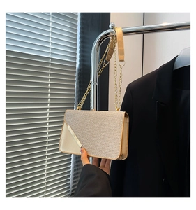 Close-up of champagne gold glitter crossbody bag with metallic edges and chain strap