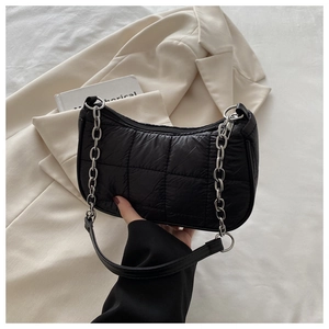 Détail du sac matelassé noir avec bandoulière chaîne argentée et fermeture éclair