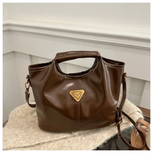 Macro detail of dark brown retro leather handbag with vintage gold metal logo buckle