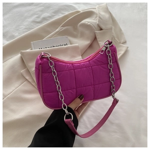 Détail du sac matelassé fuchsia avec motifs carrés et bandoulière chaîne argentée