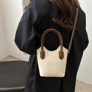 Minimalist beige bucket bag with brown handles and crossbody strap for women