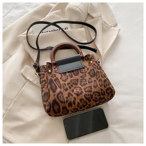Detail of leopard print tote featuring resin circular handles and detachable strap