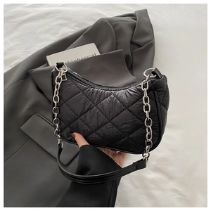 Detail of black quilted hobo bag featuring silver chain strap and puffy diamond stitching