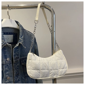 Detail of white quilted hobo bag with silver chain strap and puffy square stitching